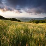 Storm clouds roll in over a grassy meadow and mountain overlook on Cole Mountain, VA on the Appalachian Trail.